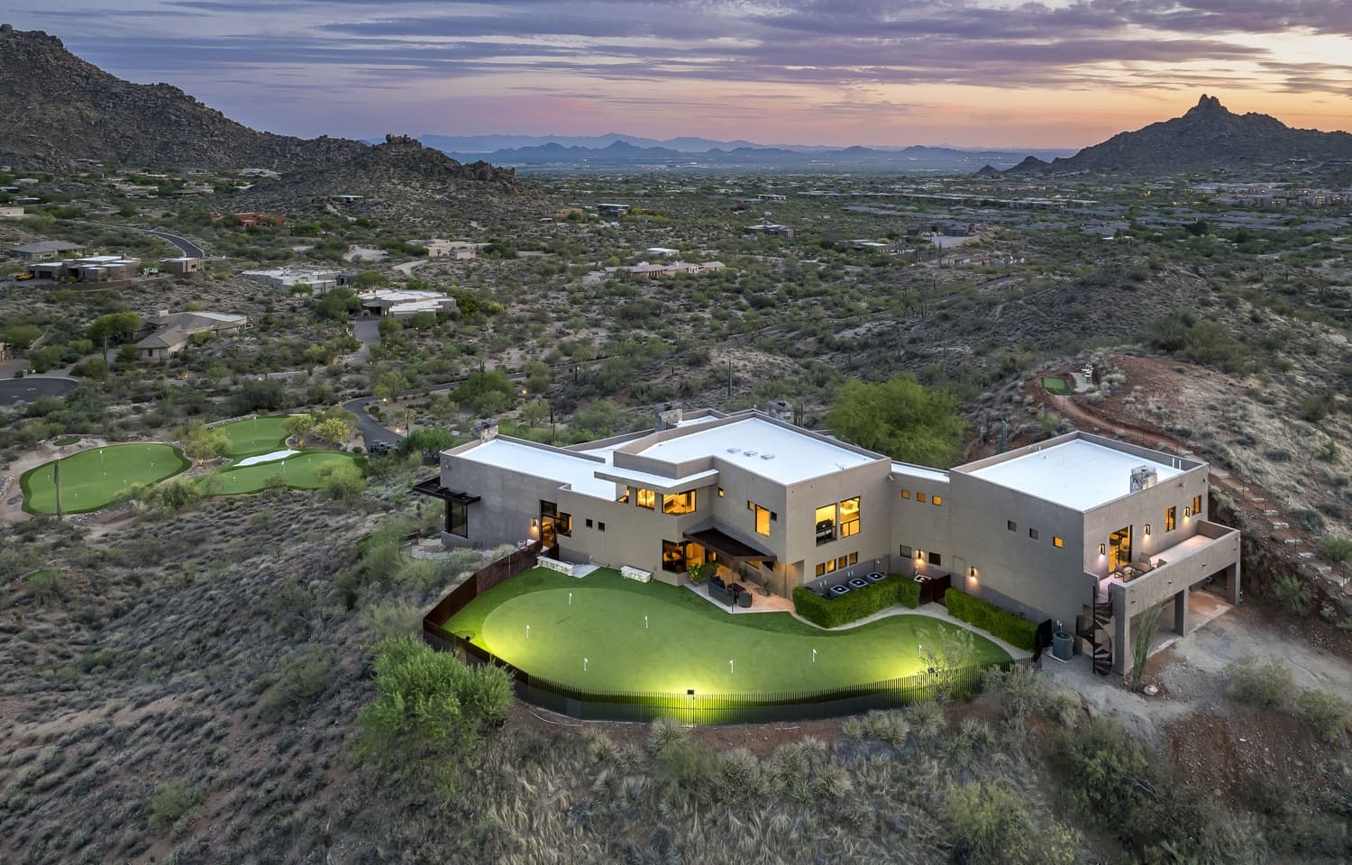The lighted backyard putting green at Saguaro Point glowing at night