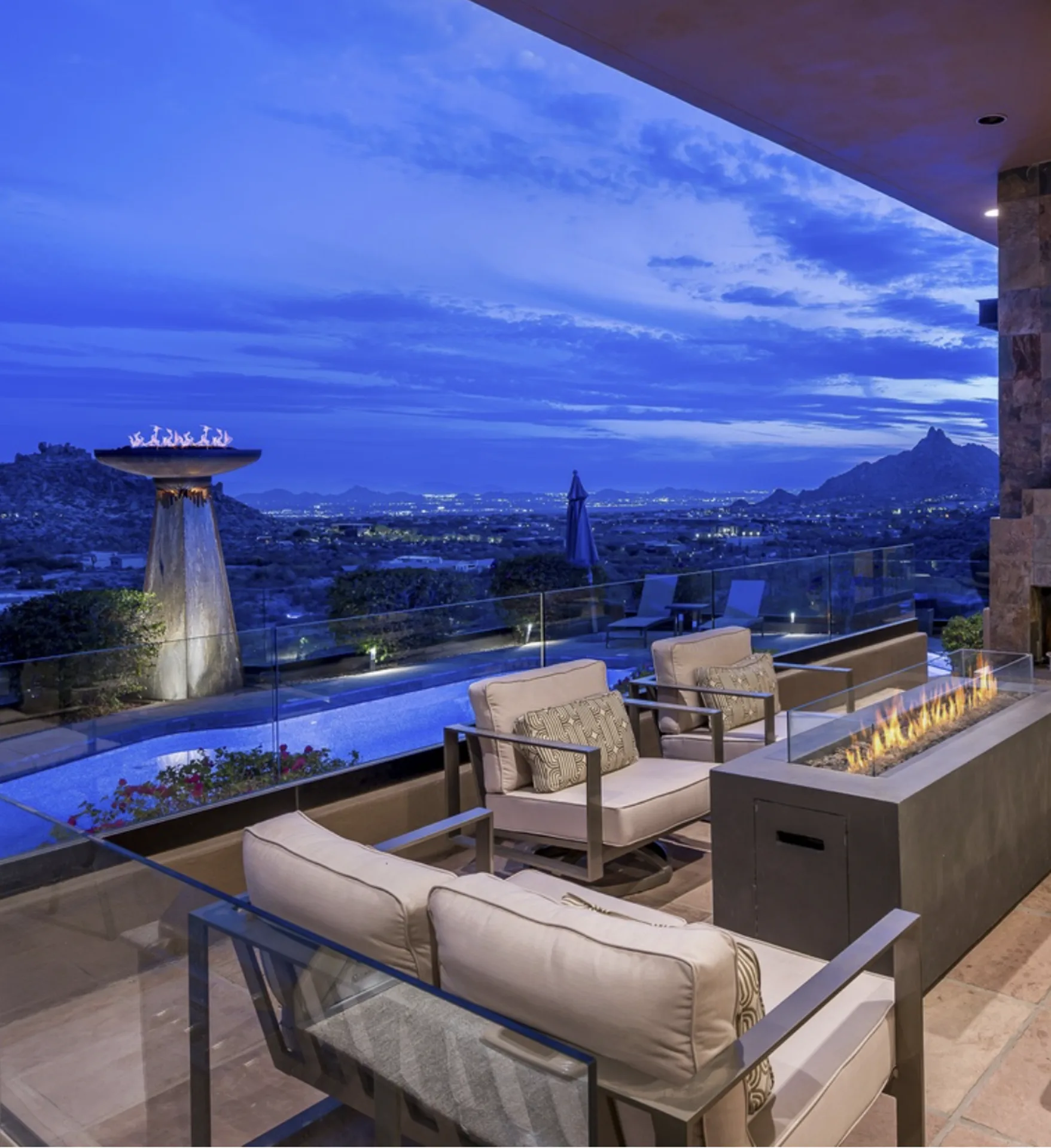 The blue-hour patio with fire bowl, pool, and Scottsdale city lights