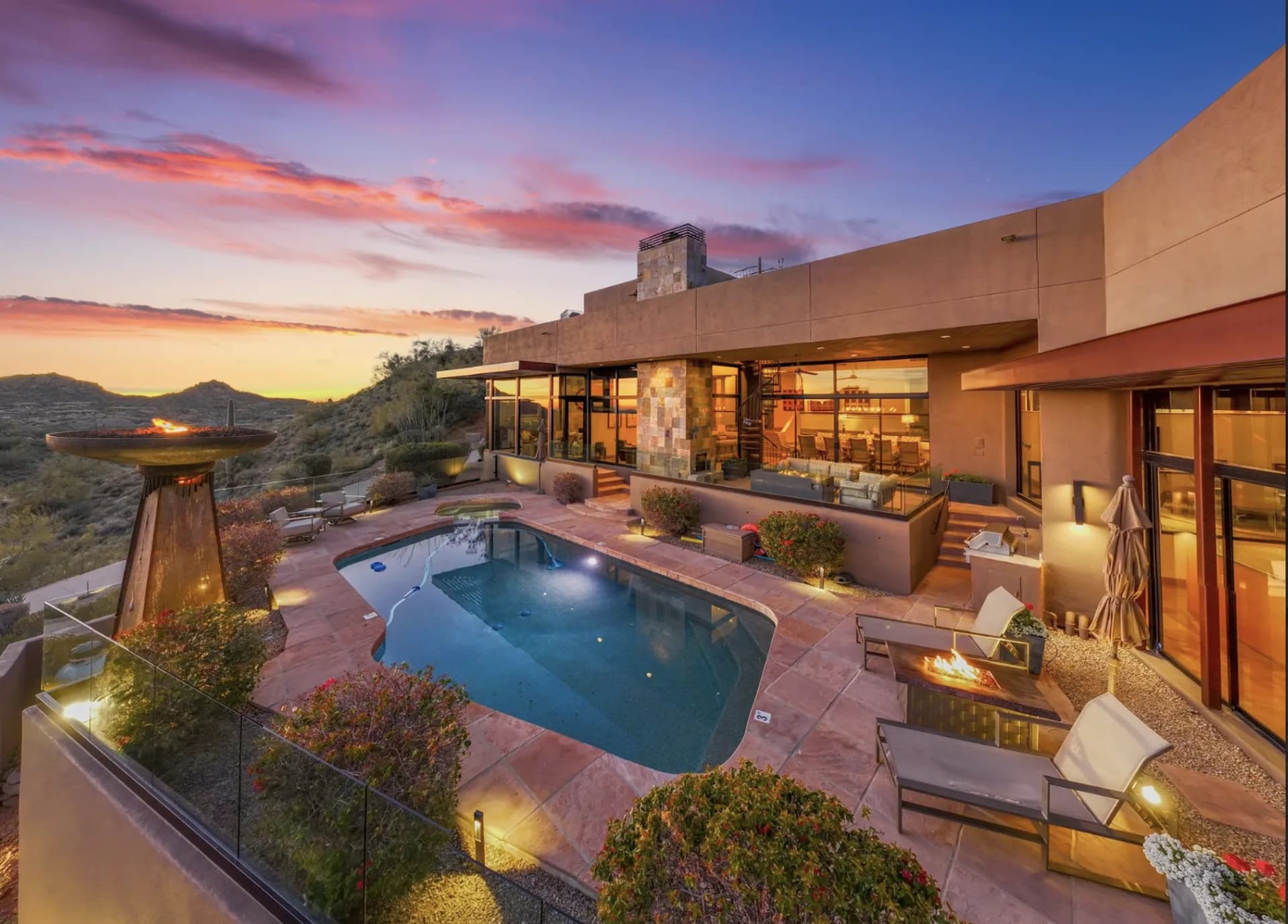 Sunset aerial of the Saguaro Point pool deck with fire features burning
