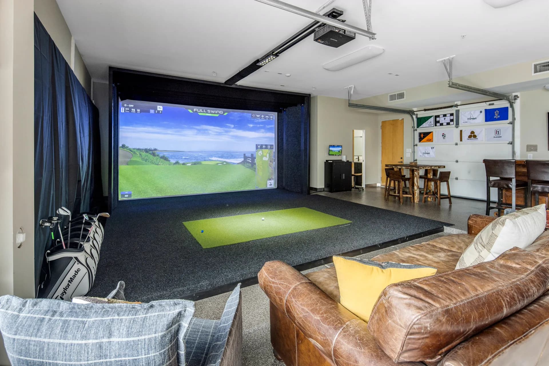 The Full Swing simulator mid-round with hitting mat and lounge seating