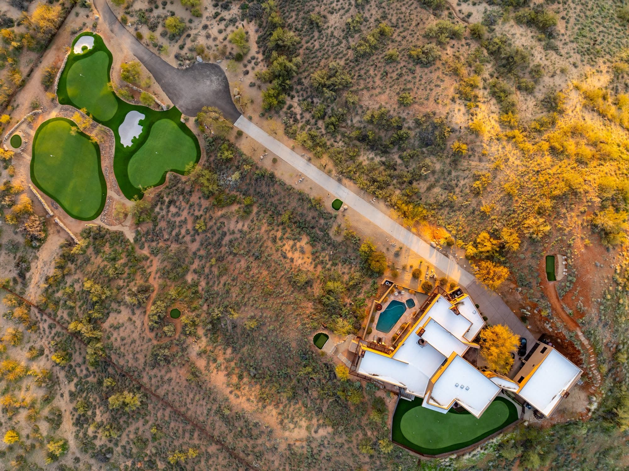 Overhead view of the estate with the greens at upper left, the driveway running diagonally through the property, and the house and pool at lower right