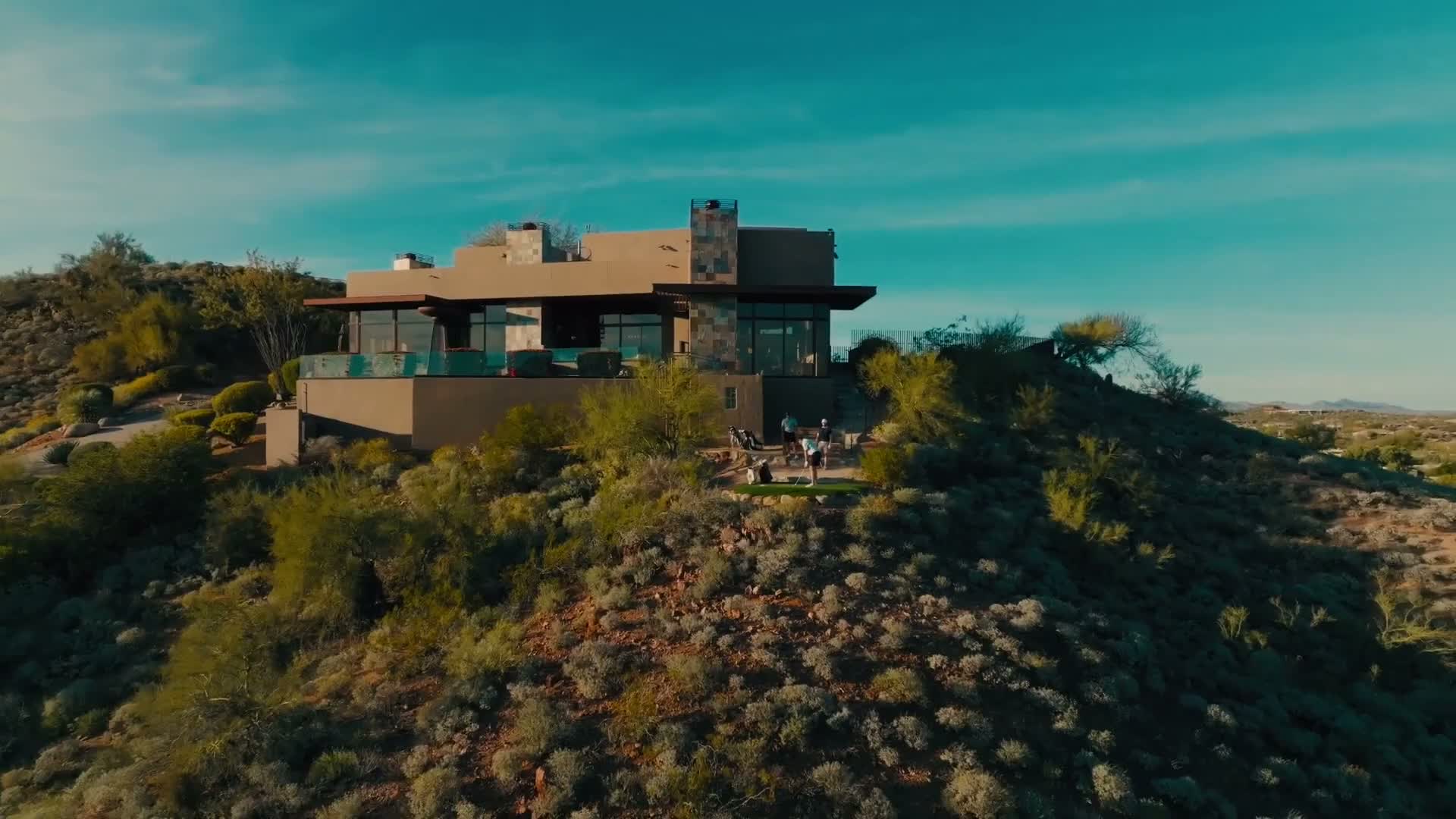 Dusk aerial approach to the Saguaro Point estate above the Scottsdale valley